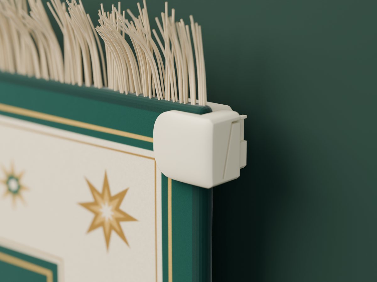 A clamp gripping the corner of a prayer mat, just below the tassels
