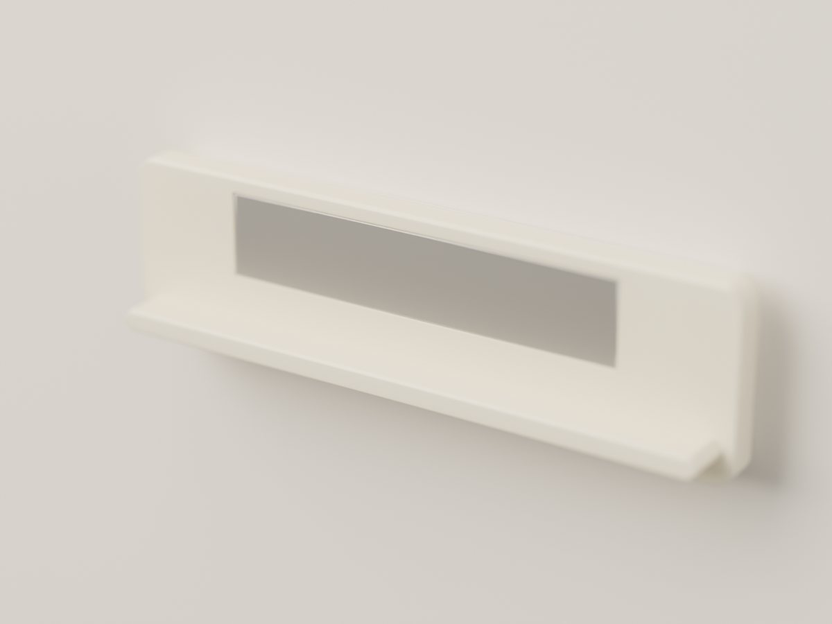 An ivory wall mount stuck to a plain wall, with its magnet and small ledge showing